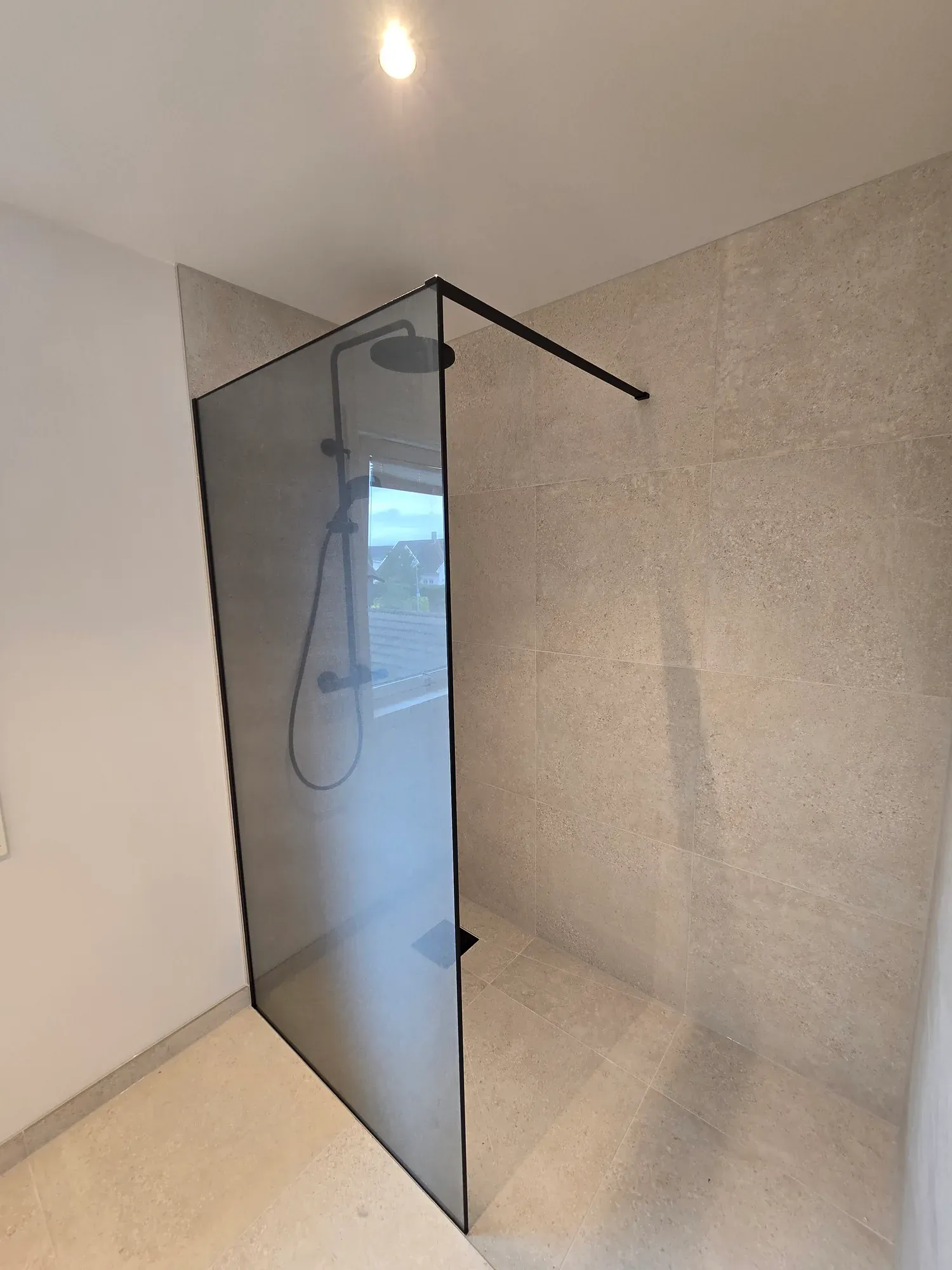 Dusjsone med glassvegg og sorte detaljer.