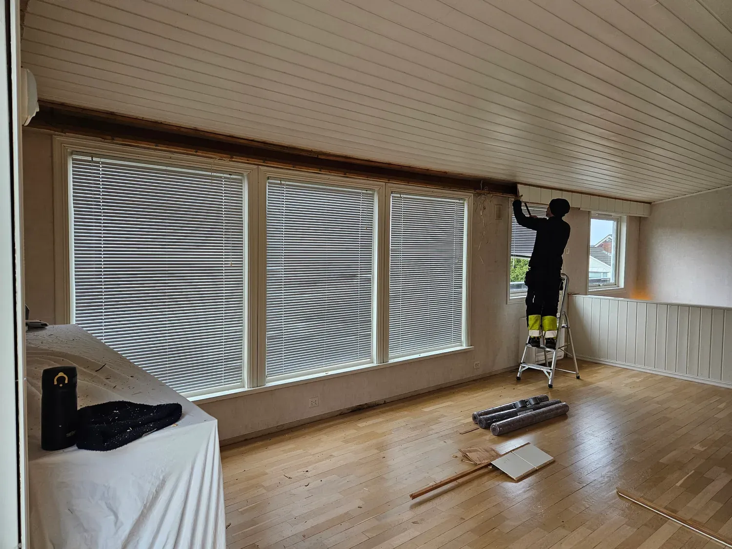 Innvendig arbeid med gulv og vindusflater.