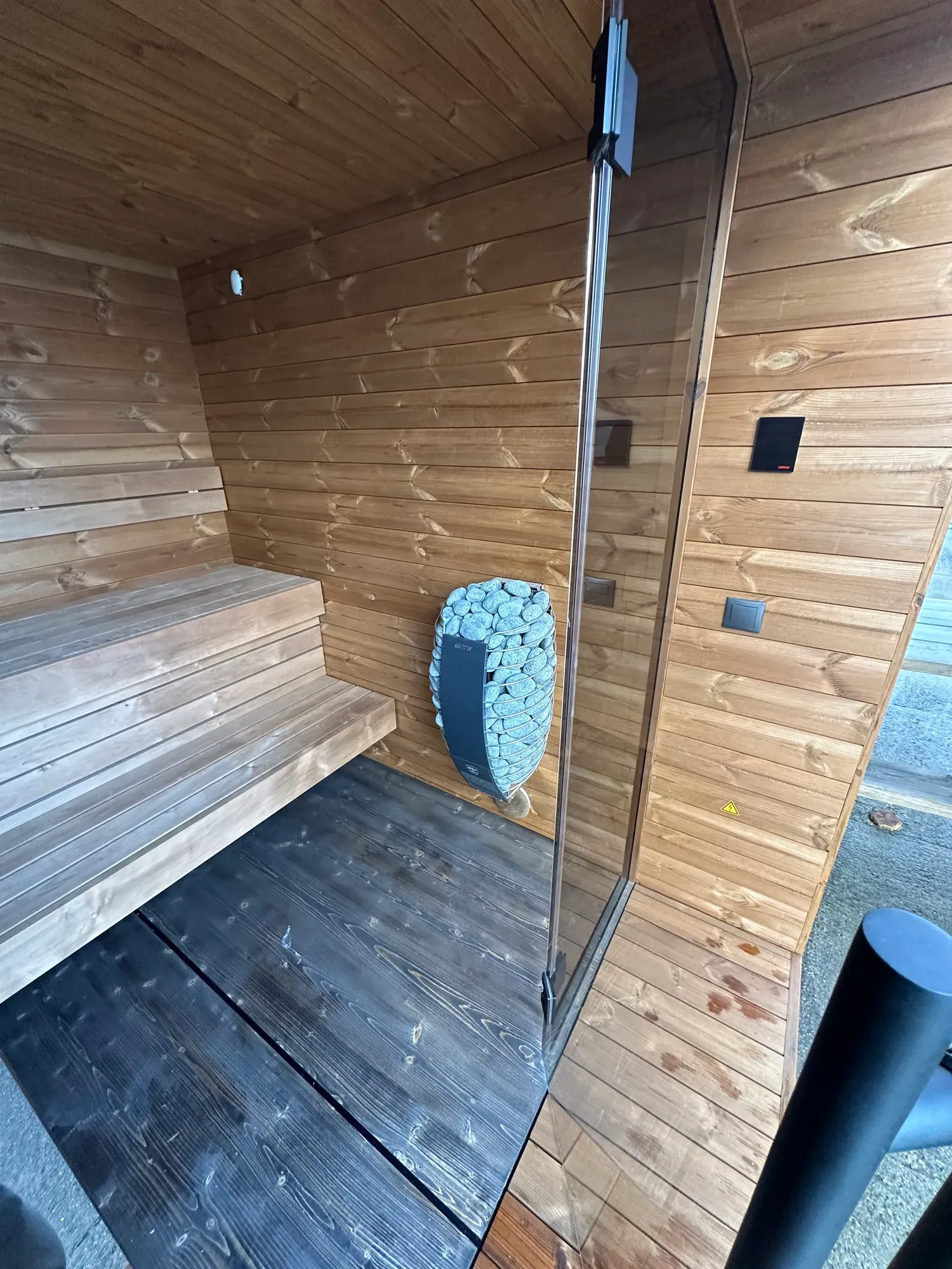 Interiør i sauna med benker og ovnssone.