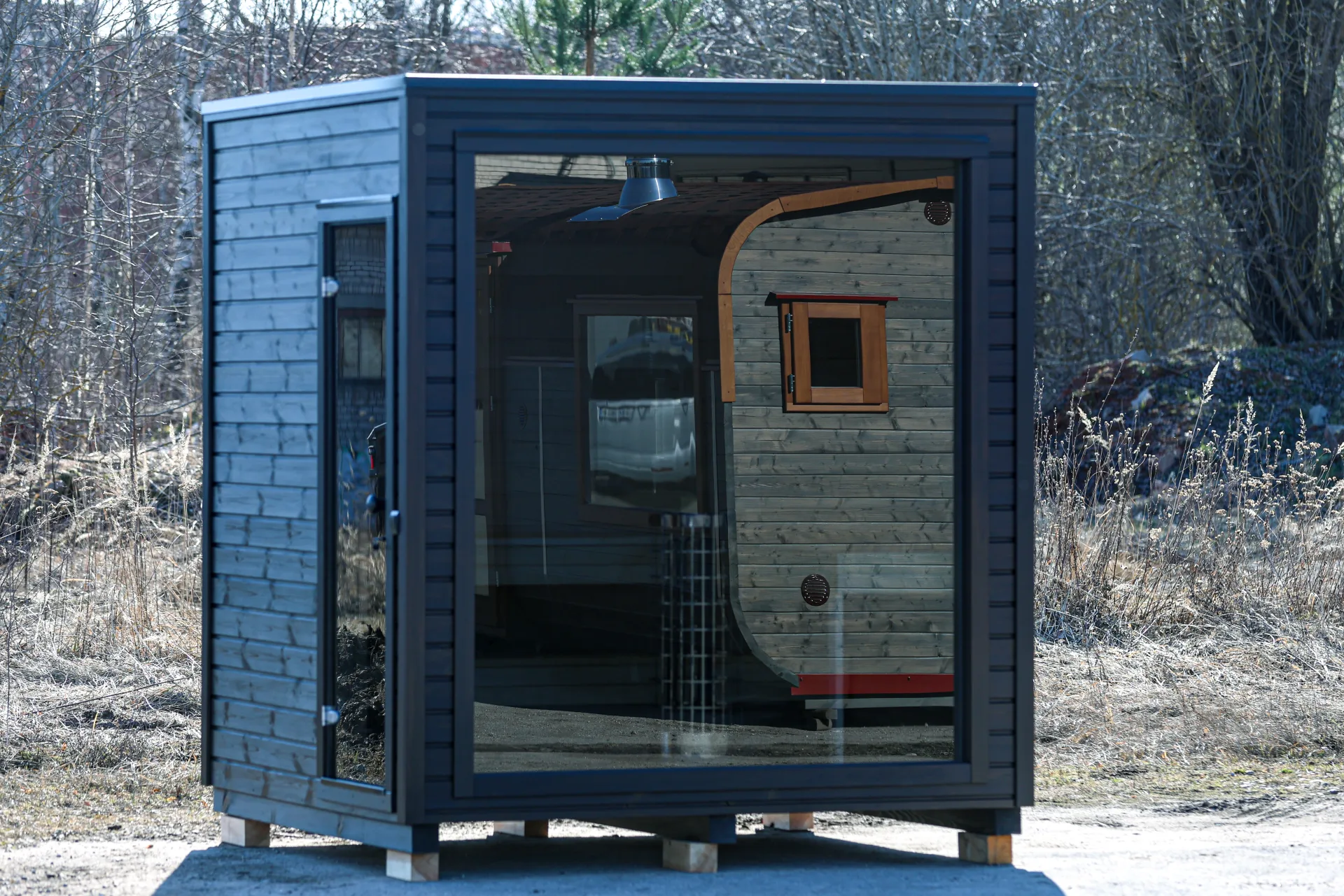 Frittstående sauna med glassfront og elektrisk ovn.