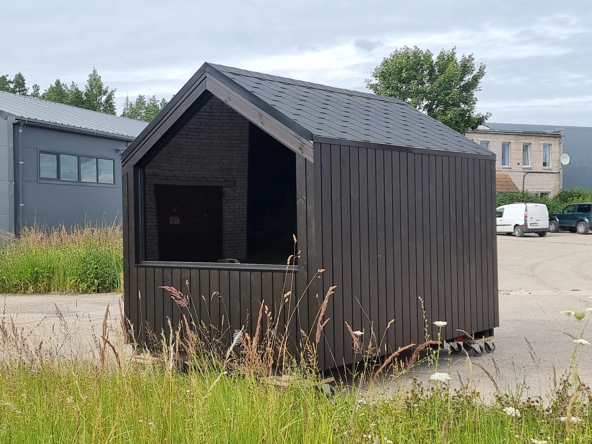 Sauna med saltak og sort kledning.