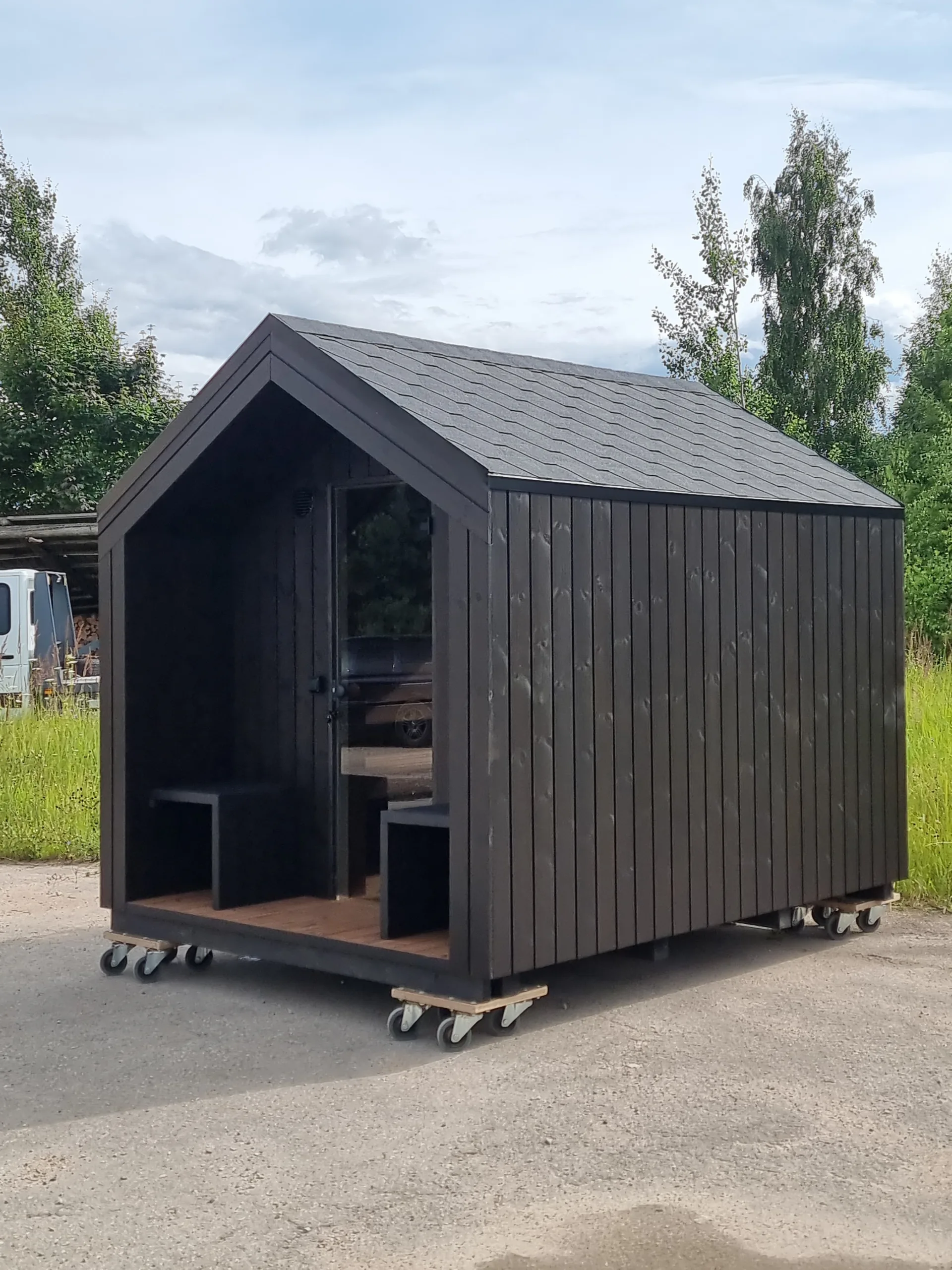 Sauna med overbygd inngang og sittebenker.