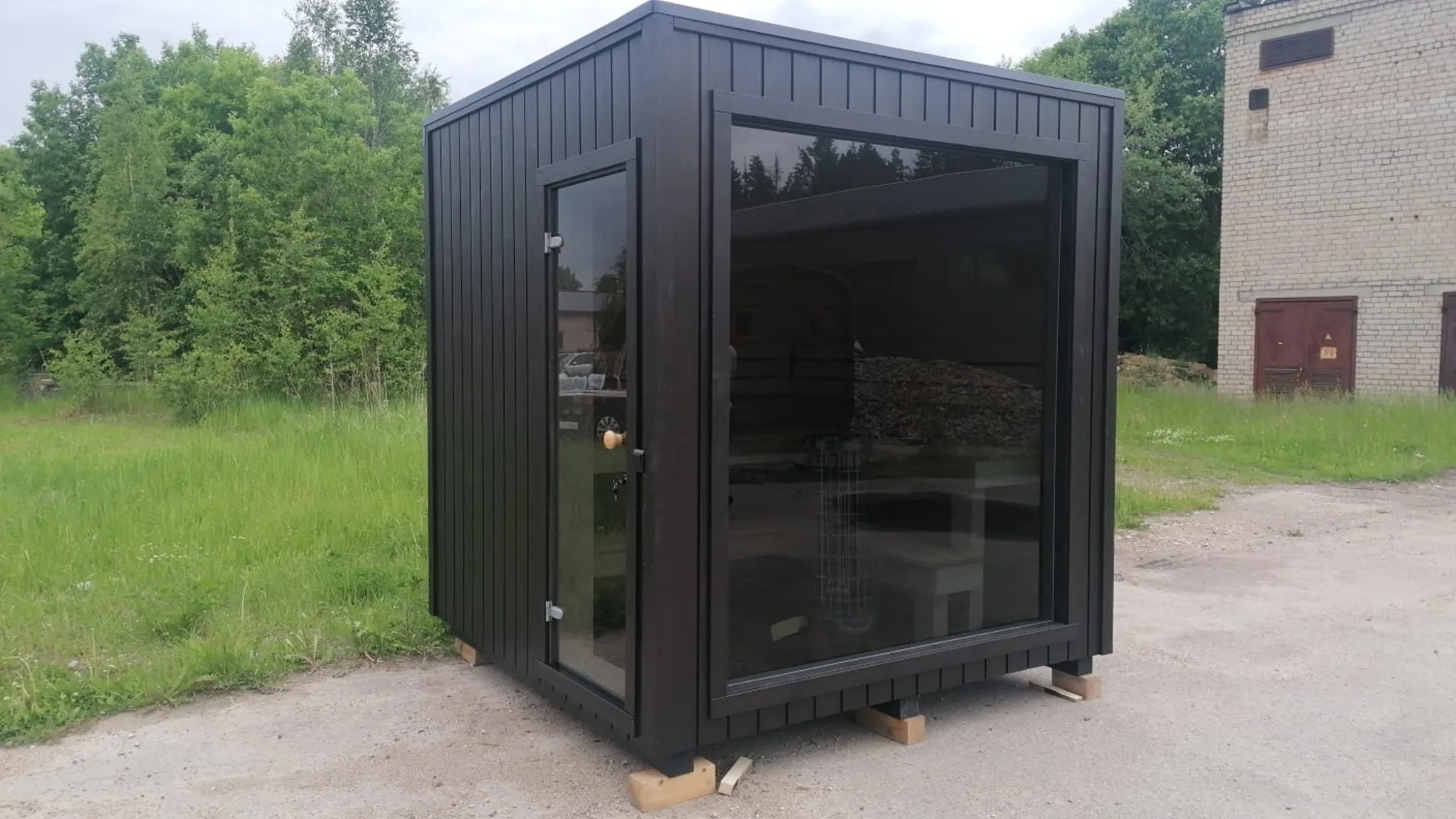 Kompakt sauna med glassdør og panoramavindu.