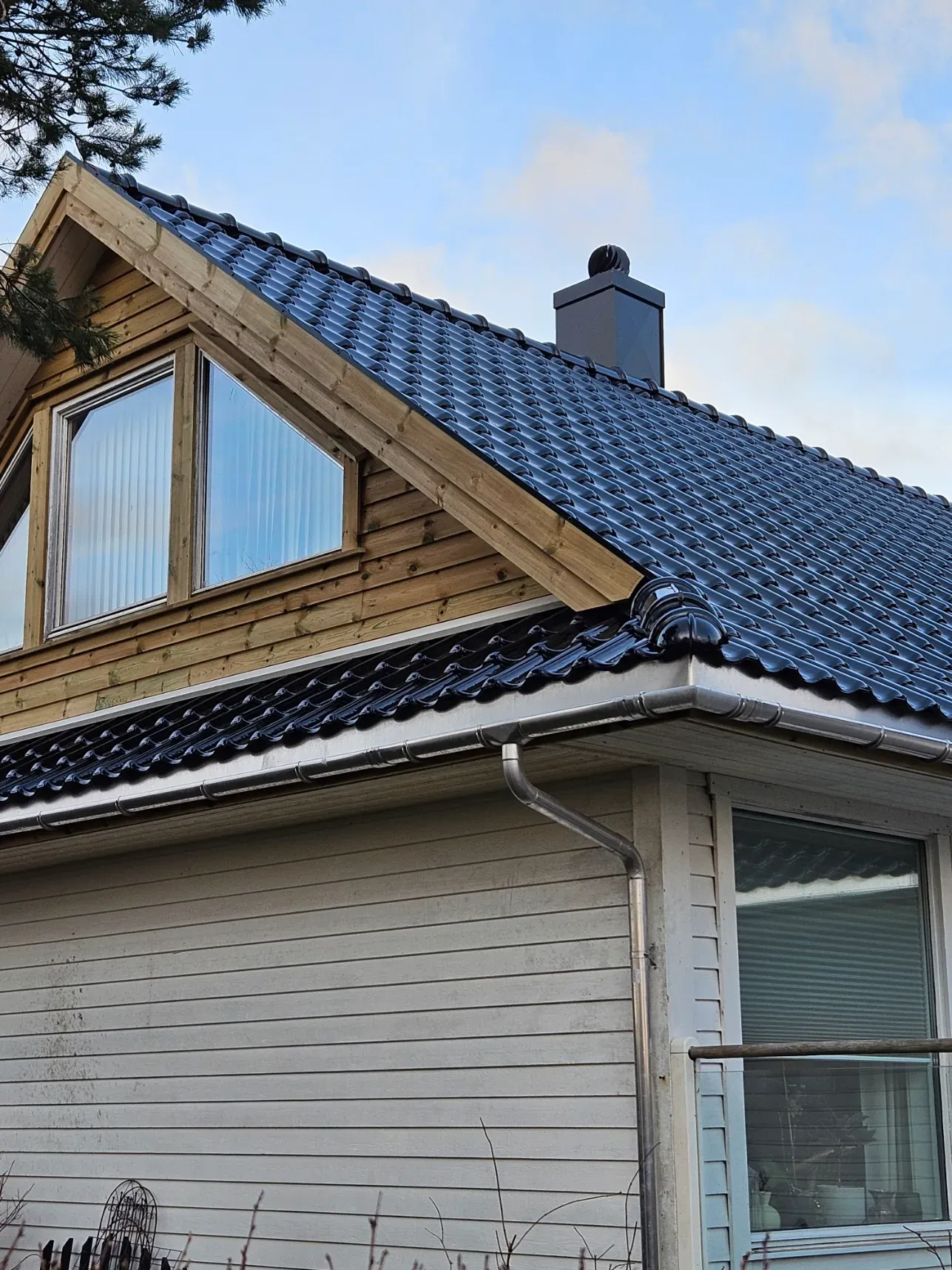Detalj av tak, renne og overgang mot fasade.